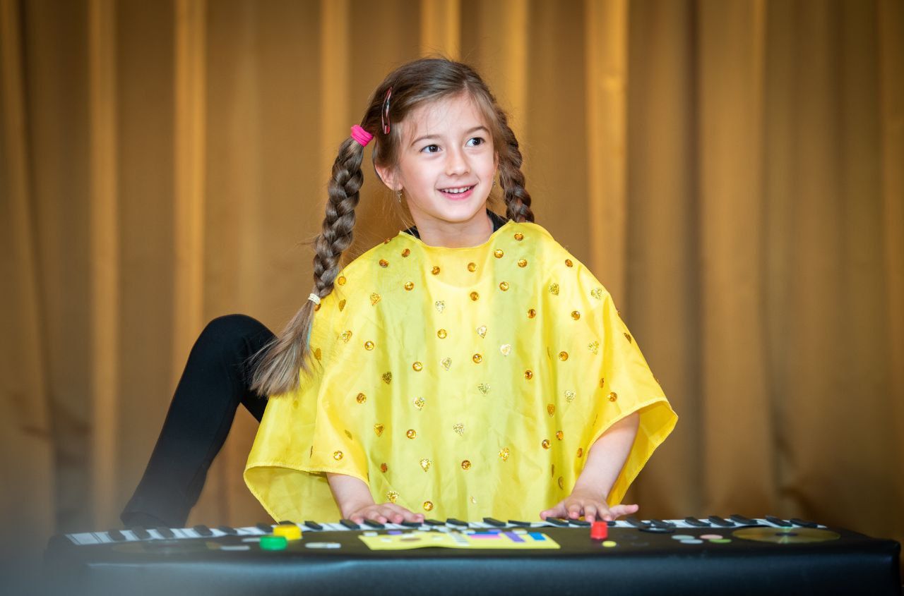Девочка играет на пианино в детской театральной студии